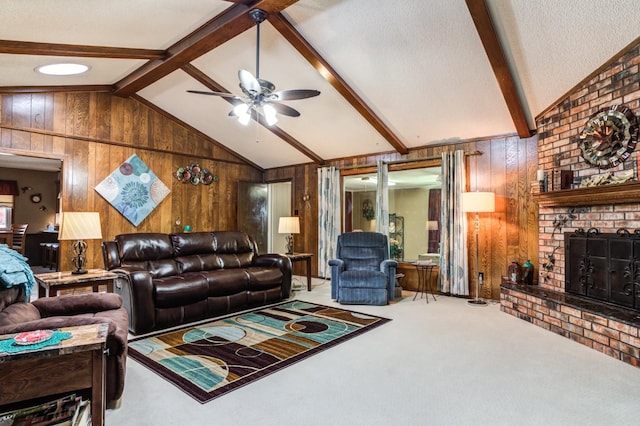 carpeted living room with wood walls, vaulted ceiling with beams, a textured ceiling, a brick fireplace, and ceiling fan