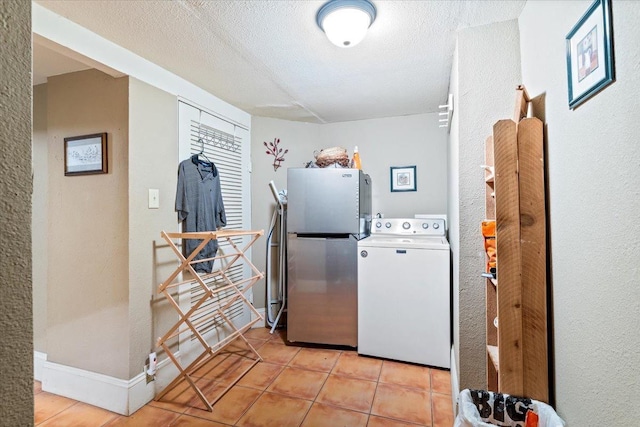 laundry area with washer / dryer, light tile patterned floors, and a textured ceiling