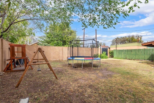 view of yard featuring a trampoline and a playground