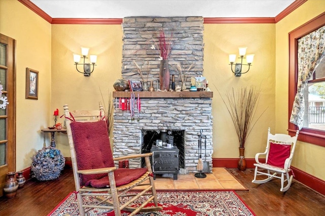 living area featuring crown molding, wood-type flooring, and a fireplace