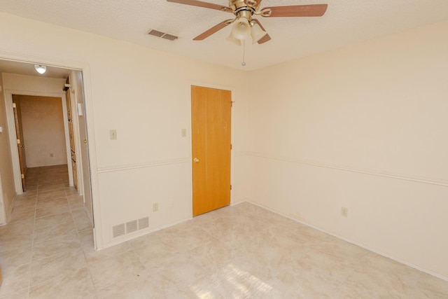 spare room featuring ceiling fan and a textured ceiling