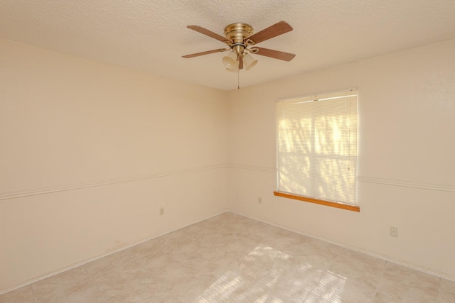 unfurnished room featuring ceiling fan and a textured ceiling