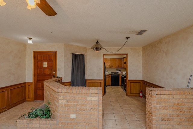 kitchen with light tile patterned floors, black appliances, a textured ceiling, and ceiling fan