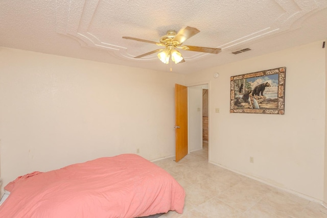 bedroom with ceiling fan and a textured ceiling