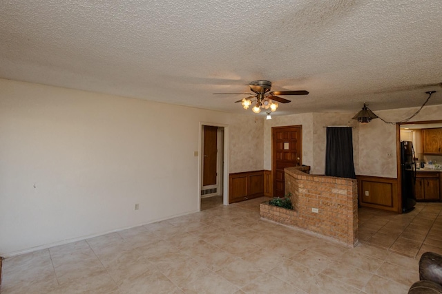 empty room with ceiling fan and a textured ceiling