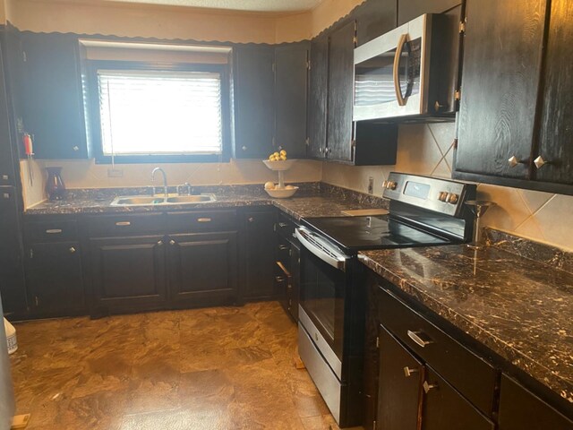 kitchen with appliances with stainless steel finishes, sink, backsplash, and dark brown cabinetry