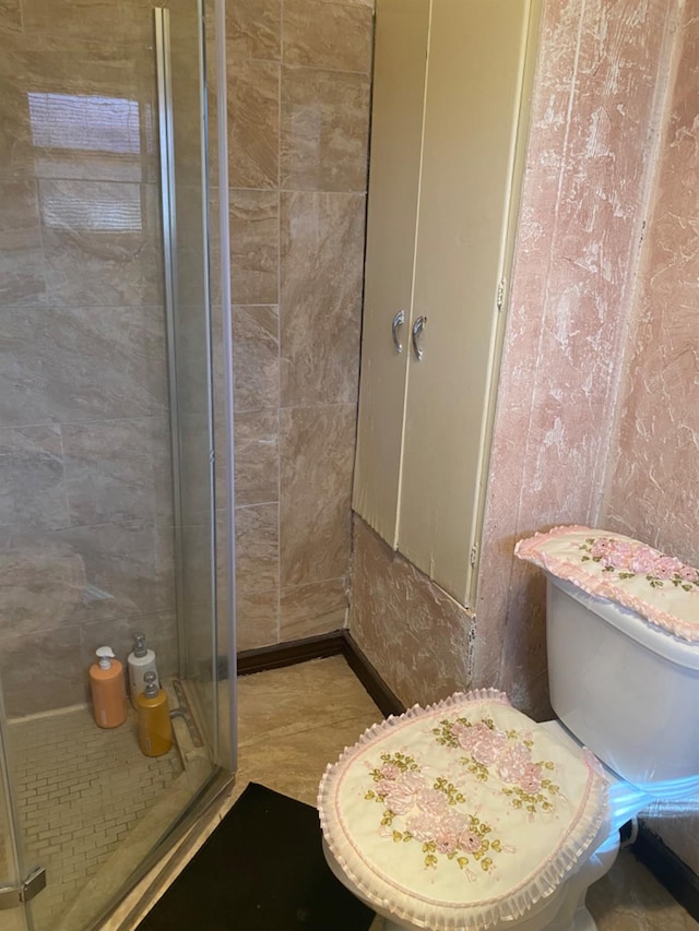 bathroom featuring an enclosed shower and toilet