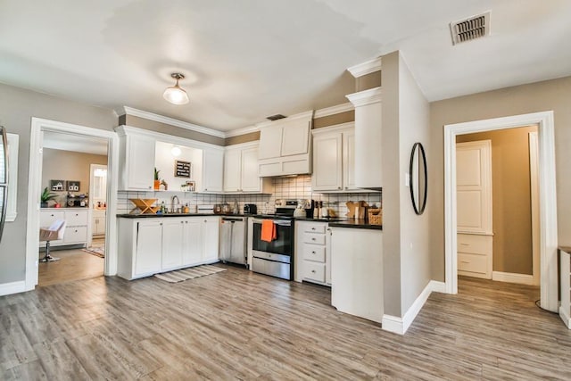 kitchen with white cabinetry, sink, decorative backsplash, stainless steel appliances, and light wood-type flooring