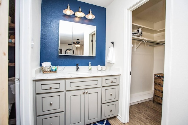 bathroom with wood-type flooring, vanity, and ceiling fan