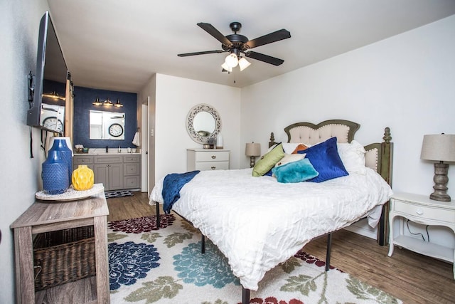 bedroom with ceiling fan, dark hardwood / wood-style floors, sink, and ensuite bath