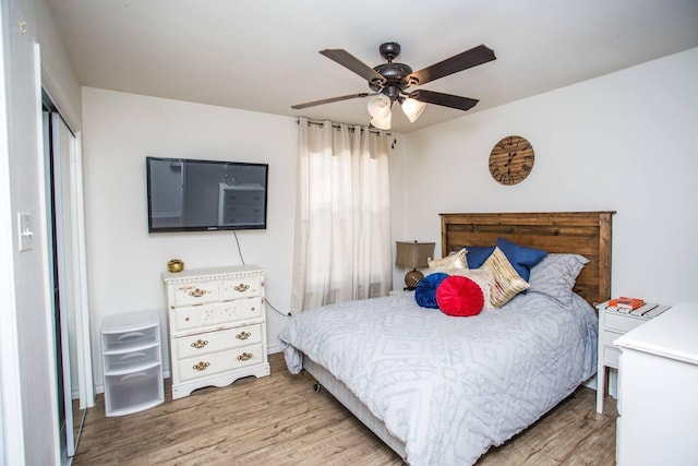 bedroom with ceiling fan, light hardwood / wood-style floors, and a closet