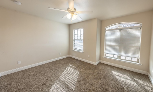 carpeted spare room featuring ceiling fan