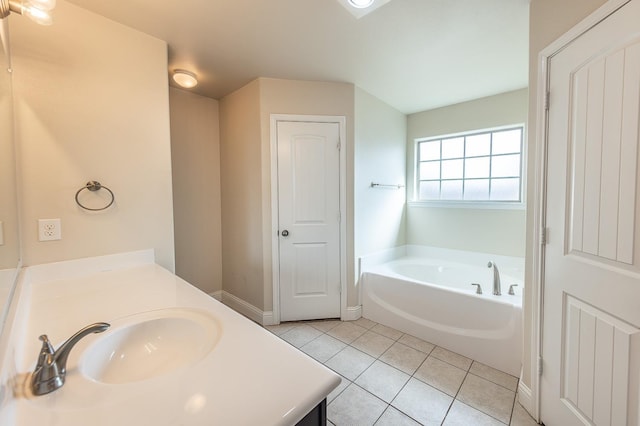 bathroom featuring tile patterned flooring, vanity, and a bath