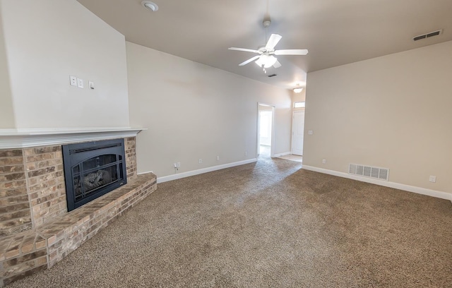 unfurnished living room featuring a brick fireplace, carpet, and ceiling fan