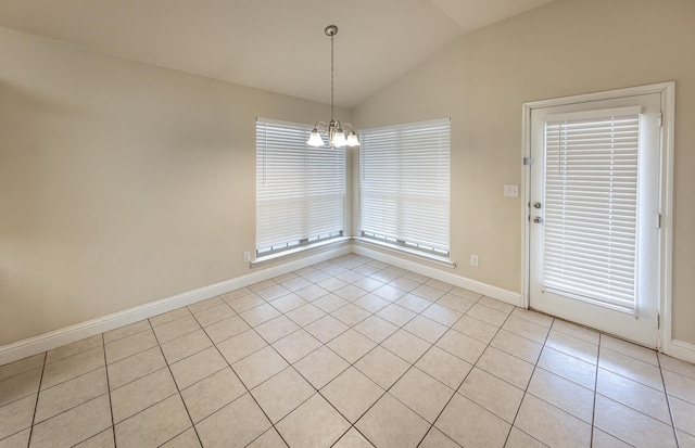 empty room featuring vaulted ceiling, light tile patterned flooring, and an inviting chandelier