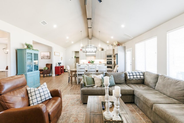 living room with beam ceiling, high vaulted ceiling, and light wood-type flooring