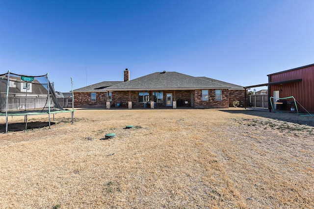 back of property featuring a trampoline