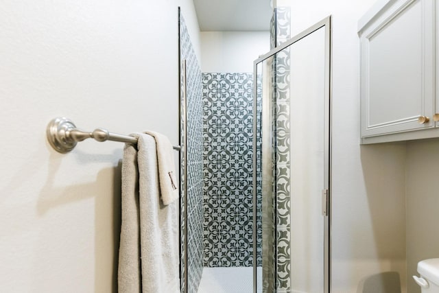 bathroom with an enclosed shower and toilet