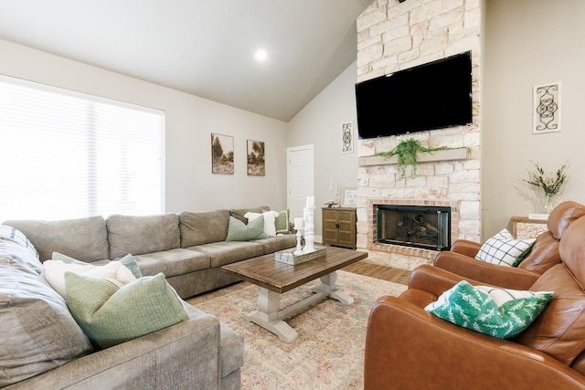 living room featuring hardwood / wood-style floors, a fireplace, and high vaulted ceiling