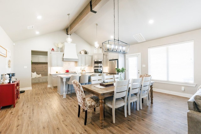 dining area with high vaulted ceiling, beam ceiling, and light hardwood / wood-style flooring