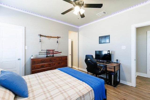 bedroom with ornamental molding, ceiling fan, and light hardwood / wood-style flooring