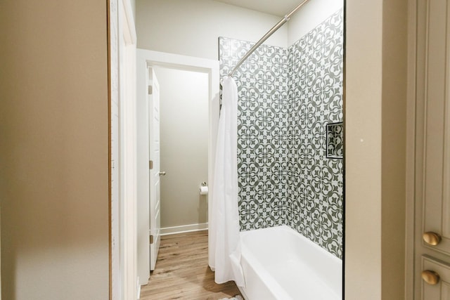 bathroom with shower / bathtub combination with curtain and wood-type flooring