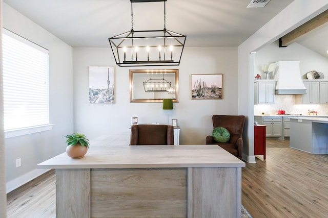 office space with lofted ceiling with beams and light wood-type flooring