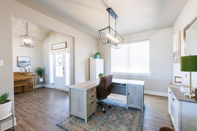 office area featuring vaulted ceiling, dark hardwood / wood-style floors, and a chandelier