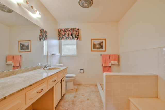 bathroom featuring tile patterned floors, toilet, tile walls, a textured ceiling, and vanity