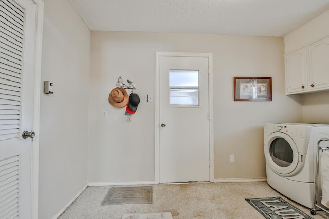 laundry room with cabinets, separate washer and dryer, light colored carpet, and a textured ceiling