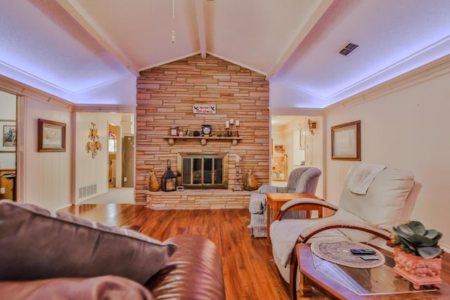 living room featuring vaulted ceiling with beams, wood-type flooring, and a fireplace