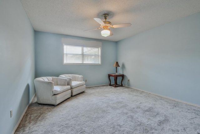 unfurnished room with light colored carpet, a textured ceiling, and ceiling fan