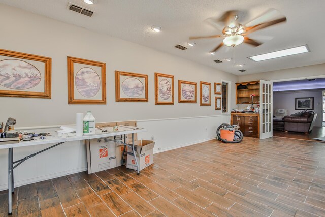 office with french doors, ceiling fan, and light hardwood / wood-style flooring