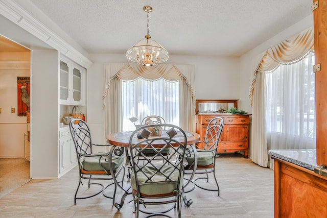 dining space featuring a notable chandelier and a textured ceiling