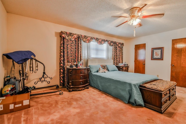 bedroom with ceiling fan, carpet floors, and a textured ceiling