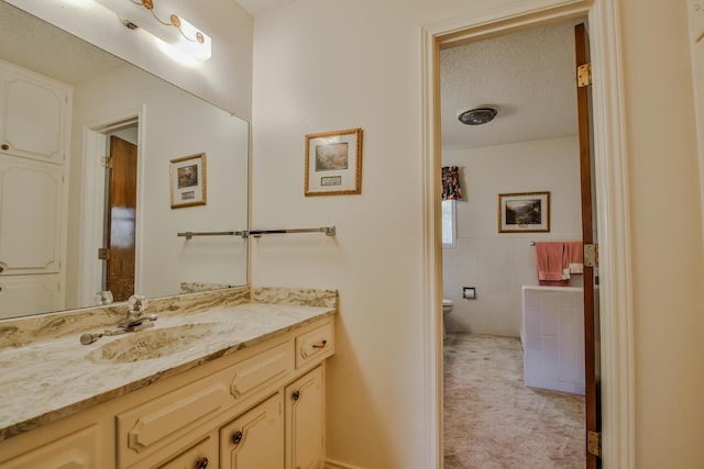 bathroom featuring vanity, tile walls, a textured ceiling, and toilet