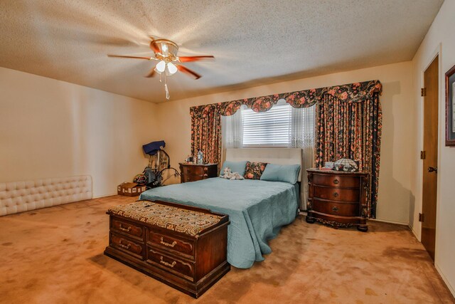 carpeted bedroom with ceiling fan and a textured ceiling