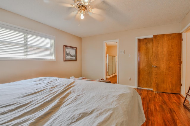 bedroom featuring ceiling fan, hardwood / wood-style floors, and a textured ceiling