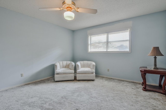 sitting room with ceiling fan, a textured ceiling, and carpet