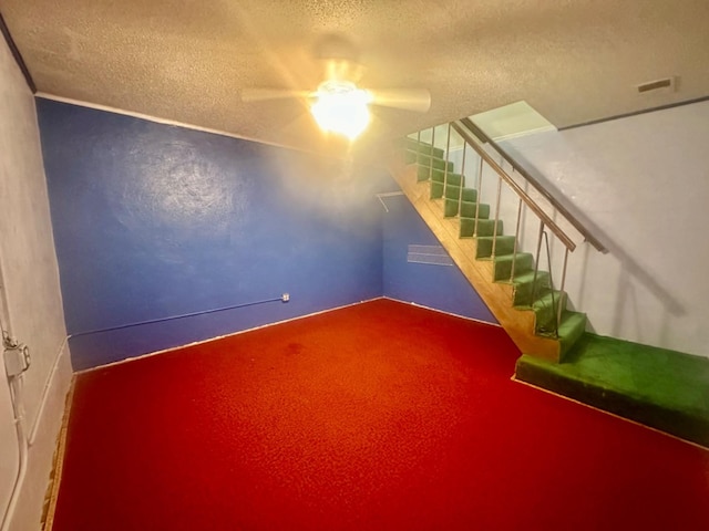 interior space with ceiling fan and a textured ceiling