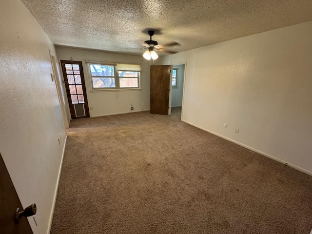 carpeted empty room featuring ceiling fan and a textured ceiling