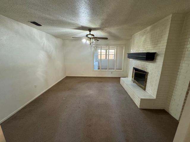 unfurnished living room featuring ceiling fan, dark carpet, a fireplace, and a textured ceiling