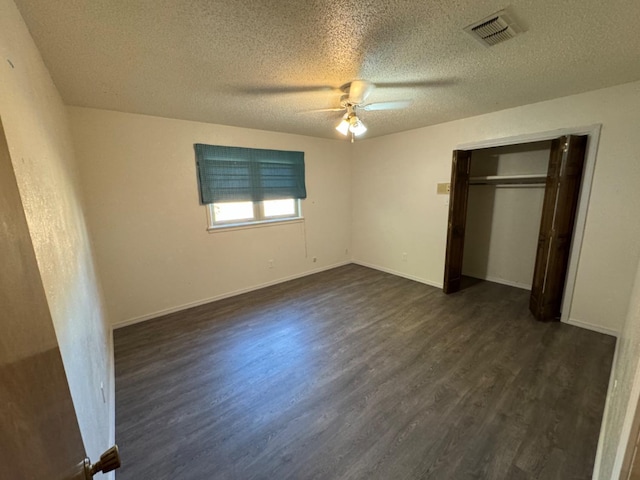unfurnished bedroom with dark hardwood / wood-style flooring, ceiling fan, a closet, and a textured ceiling