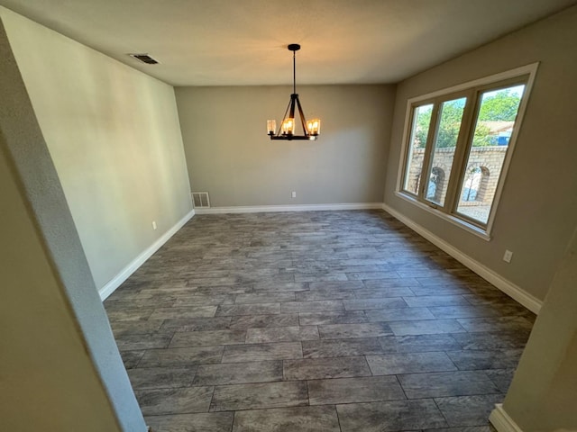 unfurnished dining area featuring a notable chandelier and dark hardwood / wood-style floors
