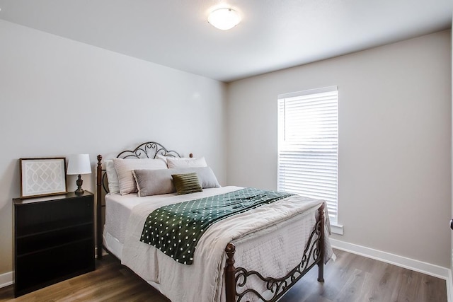 bedroom with dark hardwood / wood-style floors