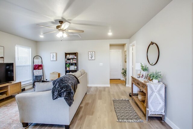 living room featuring ceiling fan and light hardwood / wood-style floors