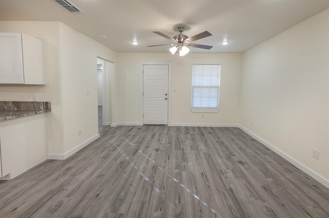 unfurnished living room with ceiling fan and light wood-type flooring