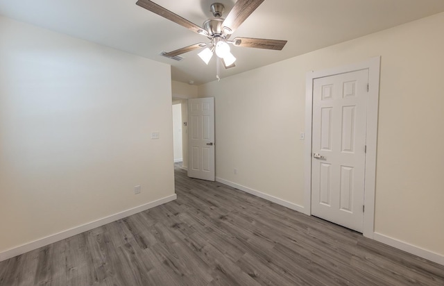 empty room with hardwood / wood-style floors and ceiling fan