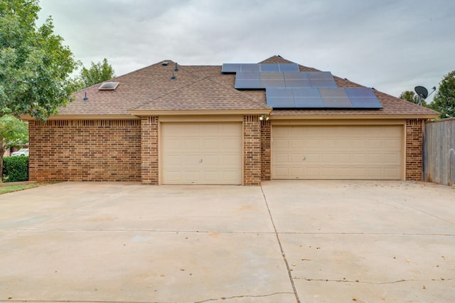 view of front of property featuring a garage and solar panels