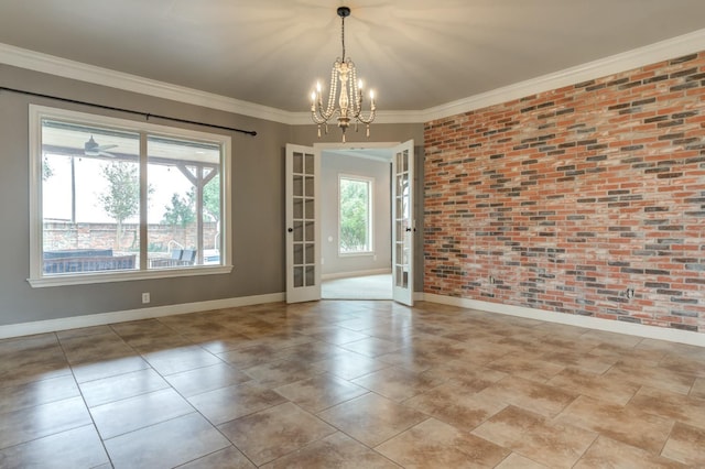 empty room with crown molding, brick wall, an inviting chandelier, and french doors